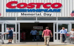 Costco warehouse entrance on Memorial Day with a “Closed” sign displayed, shoppers standing outside with carts, highlighting that Costco stores are closed for the holiday in the United States.